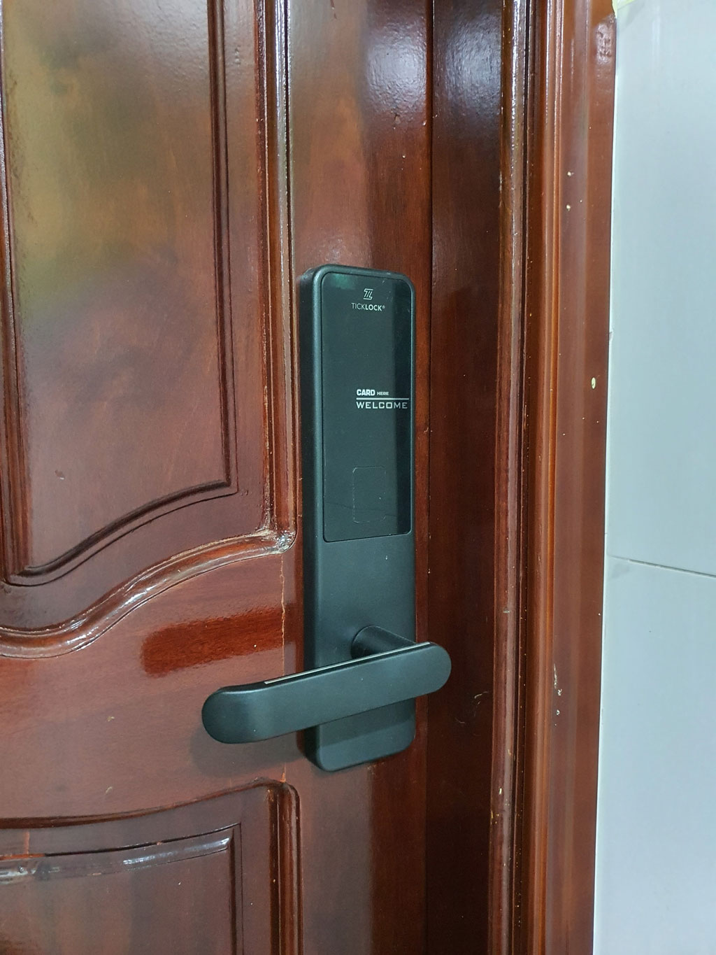 Bộ TICKLOCK SK600 lắp trên cánh cửa gỗ của một phòng lưu trú
